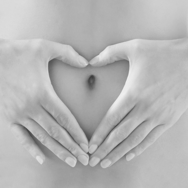 woman's hands around her belly button