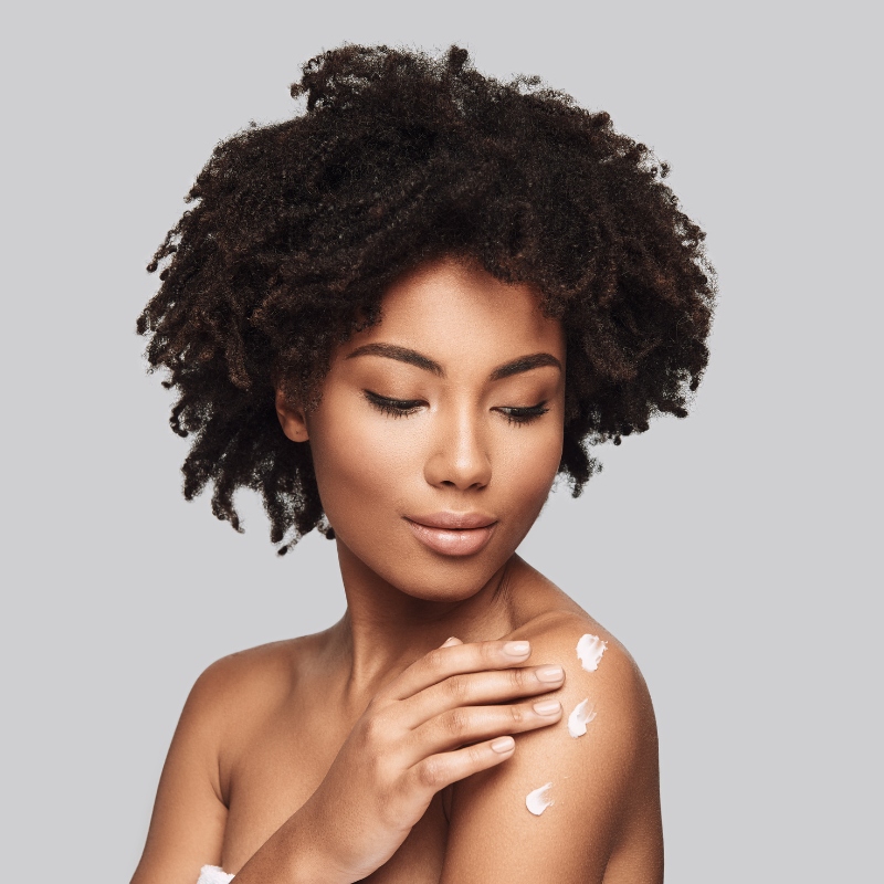 Woman applying cream to shoulder