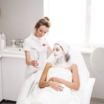 esthetician hands mirror to her client